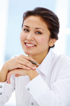 Portrait of smiling businesswoman in white shirt looking at camera