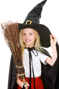 Portrait of girl in halloween costume and broom in hand posing before camera