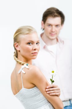Image of cute girl with white flower looking at camera over her shoulder