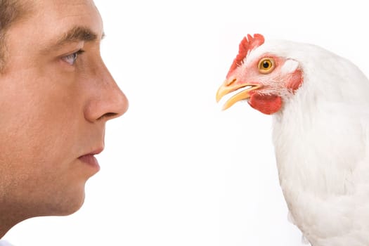 Profiles of man and white chicken looking at each other