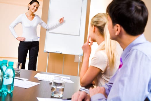 Businesswoman doing presentation on whiteboard at seminar