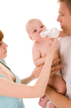 Image of baby drinking milk from bottle in female hand while being held by father