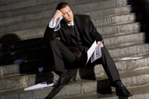 Photo of young entrepreneur holding papers and looking aside
