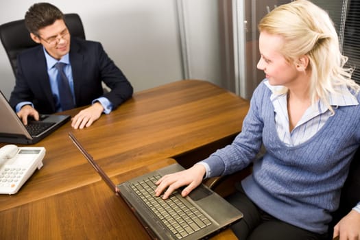 Image of secretary and boss communicating in the office at work