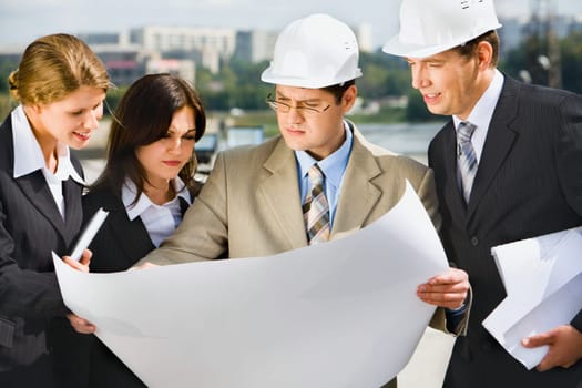 Architect is holding his project of building and showing it to customers