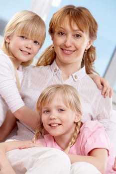 Family of woman and twin sisters looking at camera