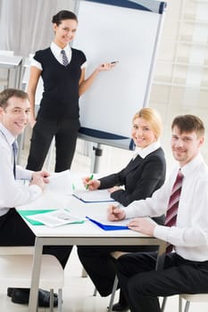 Portrait of smiling business partners looking at camera during meeting in office