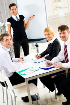 Portrait of smiling business partners looking at camera during meeting in office