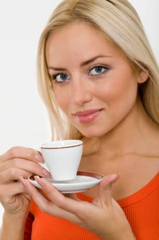 The portrait of young blonde woman with a cup of coffee in her hands