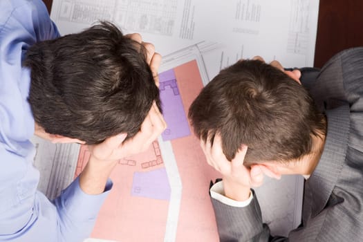 Above angle of thoughtful designers touching their heads and thinking about plan
