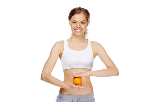 Image of young healthy woman holding an orange in front of belly