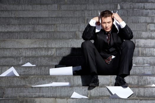 Portrait of unhappy businessman under depression touching his head in grief