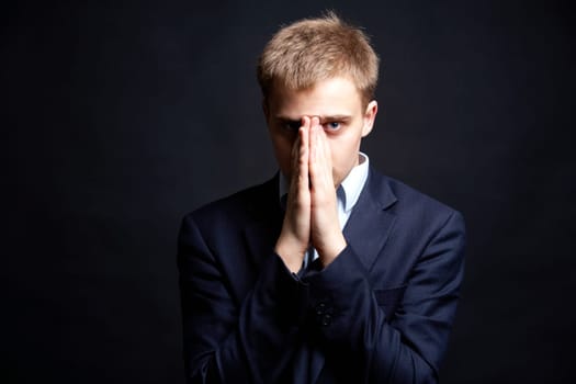 Portrait of stylish businessman looking at camera with hands by his face