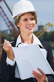 Portrait of beautiful engineer holding architectural project and pen