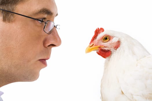 Image of man in glasses staring at curious chicken seriously