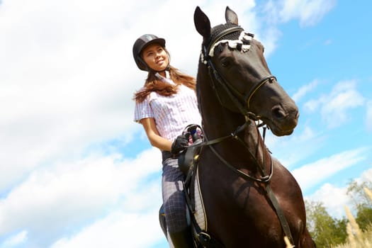 Image of happy female jockey on purebred horse outdoors