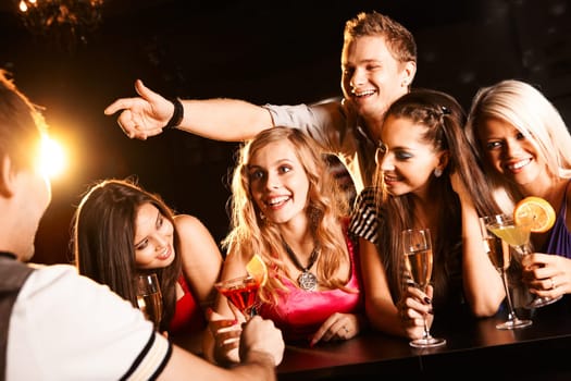 Photo of joyful friends in the bar communicating with barman