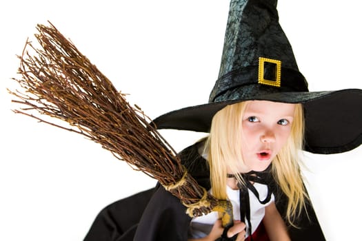 Portrait of girl in halloween costume and broom with frightening expression