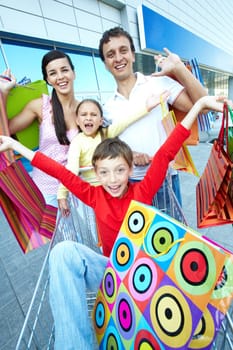 Portrait of happy shoppers with paper bags at shopping center