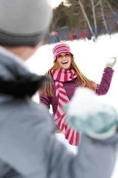 Image of attractive young woman flinging the snowball