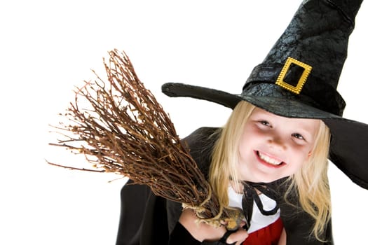 Portrait of girl in halloween costume and broom smilling at camera