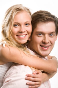 Image of happy couple looking at camera with smiles while pretty blonde embracing her boyfriend