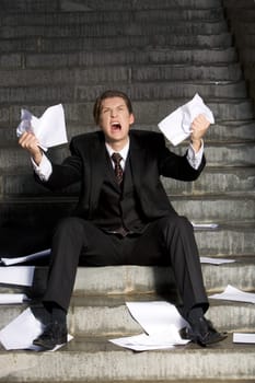 Image of grieving businessman crying with papers in hands