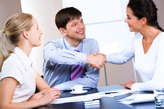 Portrait of woman and man concluding a bargain at business meeting