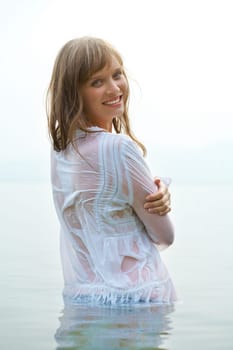 Portrait of pretty girl in water looking at camera during summer vacation