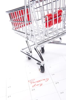 Shopping day reminder in calendar and shopping cart model - shopaholic concept. Look forward to shopping.