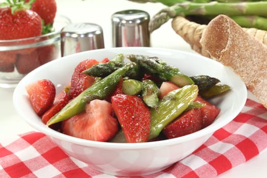 a bowl of asparagus and strawberry salad with fried green asparagus