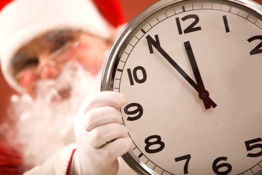 Photo of clock showing five minutes to midnight with Santa on background