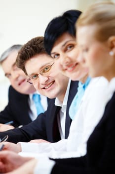 Confident businessman looking at camera among colleagues