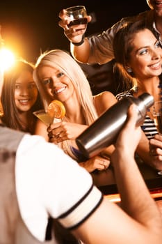 Photo of pretty girls toasting and looking at barman