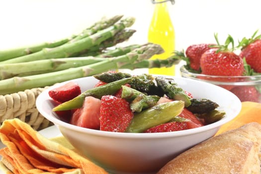 a bowl of asparagus and strawberry salad with fried green asparagus
