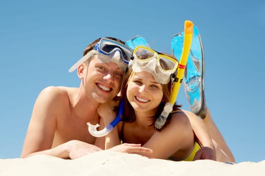 Portrait of cheerful couple in aqualungs looking at camera with smiles