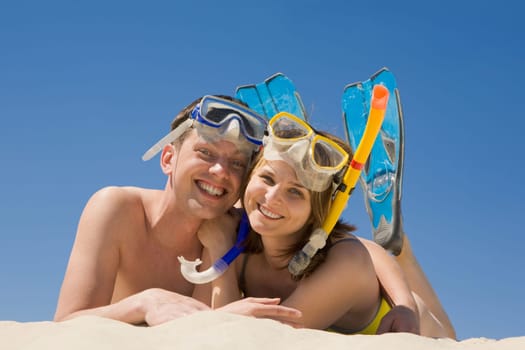 Portrait of cheerful couple in aqualungs looking at camera with smiles