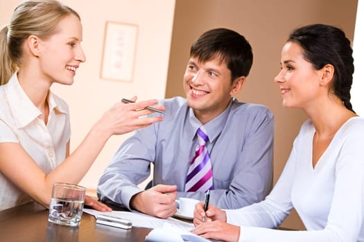 Business people gathered together around the table and discussing working questions