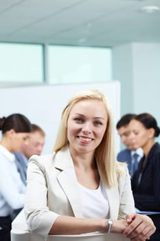 Young female leader against her business team