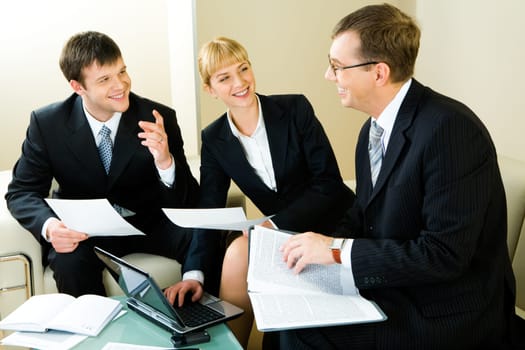 Image of three confident entrepreneurs discussing a new business decision