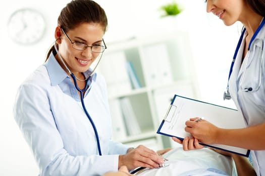 Portrait of confident female doctors during medical treatment of patient in hospital