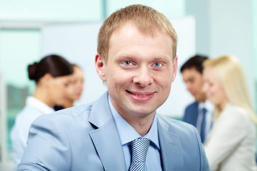 Portrait of smart employer looking at camera in working environment