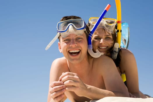 Portrait of cheerful divers lying on sand and enjoying themselves