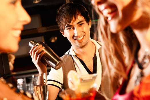Portrait of smiling male with bottle looking at camera in the bar