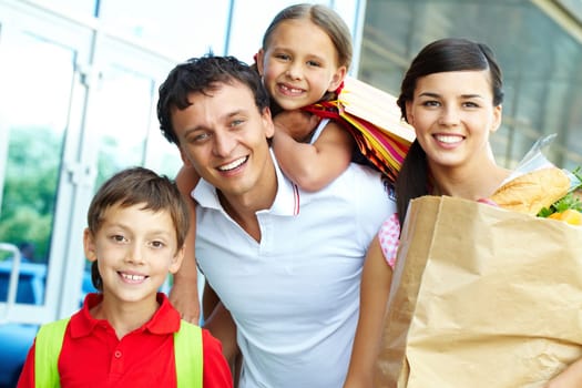 Couple with paperbags and their two children after shopping