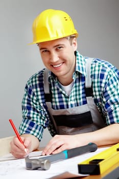 Portrait of a smiling architect making corrections on a plan
