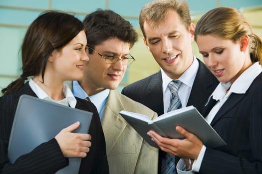 Confident smiling professionals are discussing  a conditions of contract on the background of building