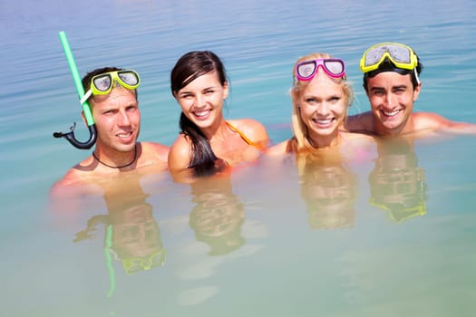 Portrait of two happy couples in water on summer vacation