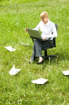 Photo of happy business lady working with laptop outside looking at its monitor