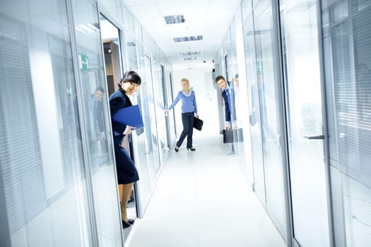 Office corridor and people looking out from the rooms